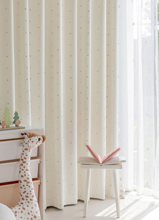 a toy giraffe sitting on top of a bed next to a window