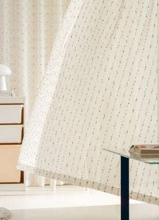 ein Zimmer mit einem Glastisch und einem weißen Vorhang