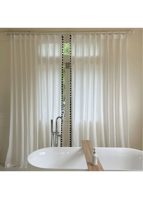 Eine weiße Badewanne steht neben einem Fenster