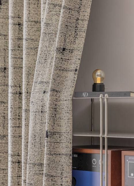 a room with a shelf and a window with a curtain