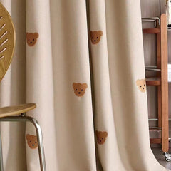 ein Zimmer mit einem Stuhl und einem Vorhang mit Teddybären darauf