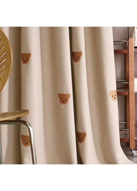 ein Zimmer mit einem Stuhl und einem Vorhang mit Teddybären darauf