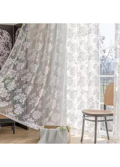 ein Wohnzimmer mit einem Sessel und einem Vorhang