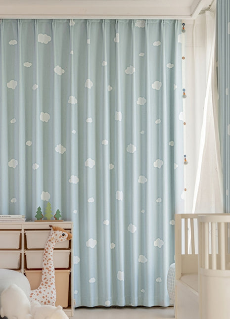 a baby's room with blue curtains and a white crib