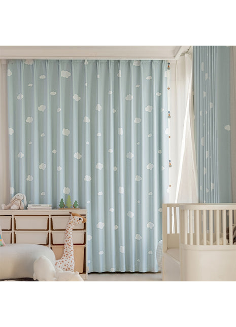 Ein Babyzimmer mit blauen Vorhängen und einem weißen Kinderbett