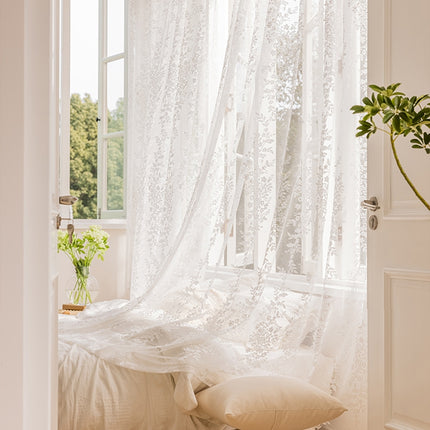 a bedroom with a white bed and a window