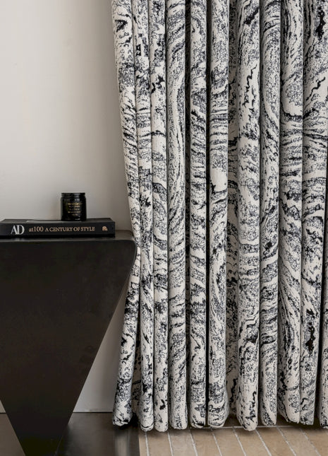 a black and white curtain next to a black table