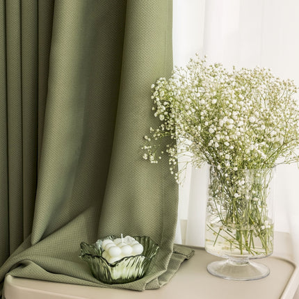 a vase of flowers sitting on a table next to a curtain