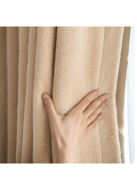 Die Hand einer Person am Vorhang eines Fensters