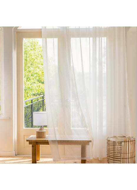 ein Zimmer mit einem Tisch und einem weißen Vorhang