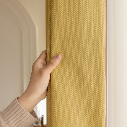 a person is holding a yellow curtain in their hand