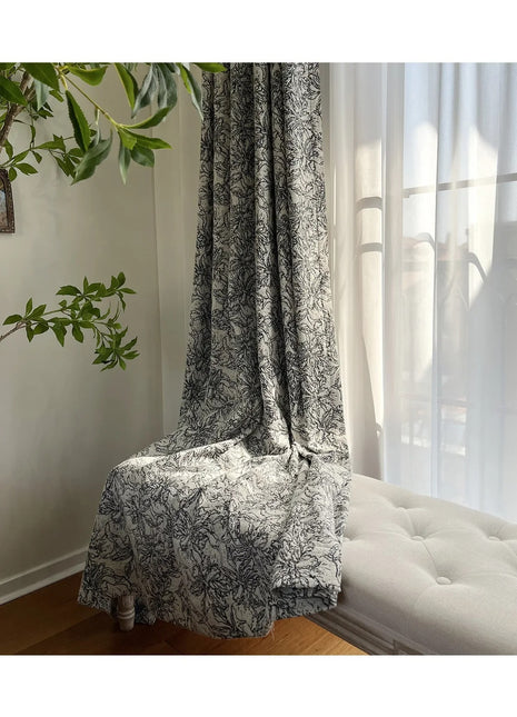 Ein weißes Sofa steht unter einem Fenster neben einer Pflanze.
