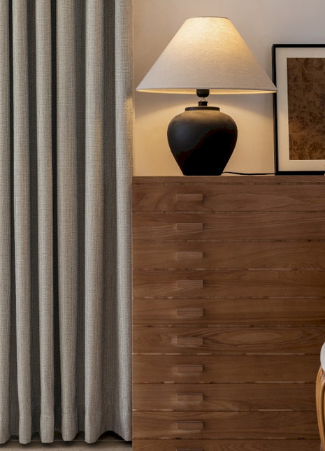 a living room with a lamp a chair and a window