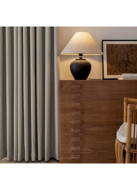 ein Wohnzimmer mit einer Lampe, einem Stuhl und einem Fenster