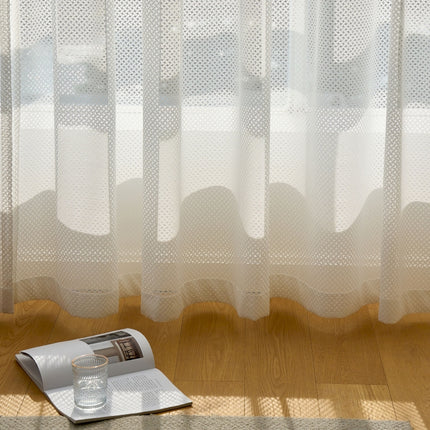 a magazine sitting on a wooden floor next to a window