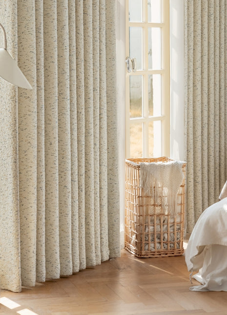 a bedroom with a bed and a window with curtains