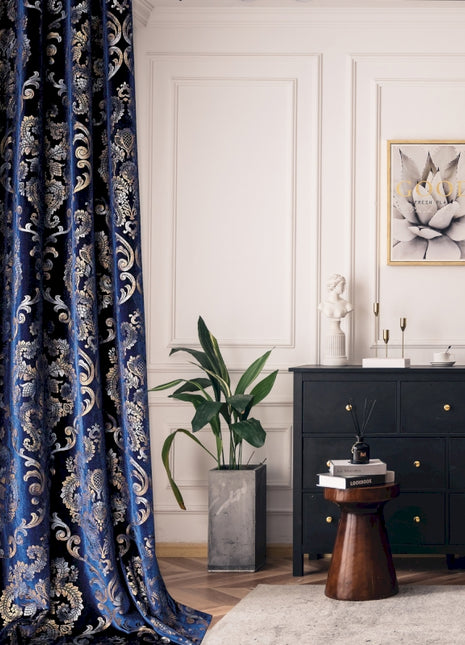 a living room with a black dresser and a blue curtain