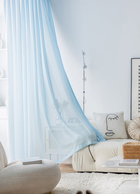 a living room with a white couch and blue drapes