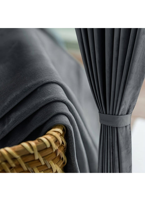 Rideau occultant en velours gris anthracite drapé près d'une fenêtre de salon