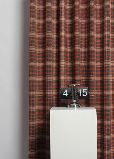 Eine Uhr auf einem Sockel vor einem Vorhang