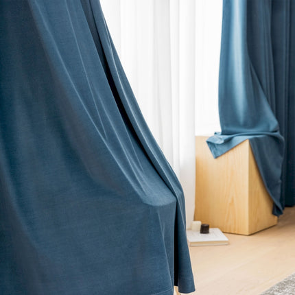a room with a blue curtain and a wooden floor