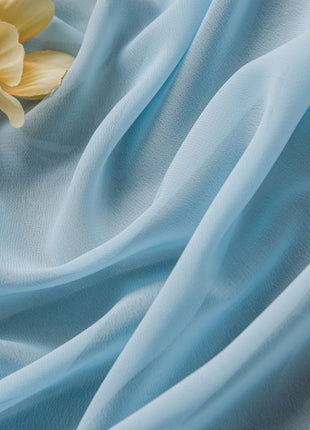Eine gelbe Blume liegt auf einem blauen Tuch