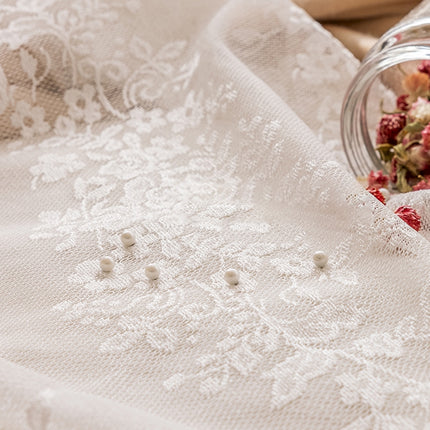 a glass jar filled with flowers sitting on top of a table