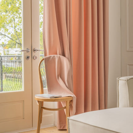 a chair sitting in front of a window next to a bed
