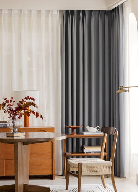 a living room with a table a chair and a window