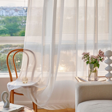 a living room with a chair and a vase of flowers