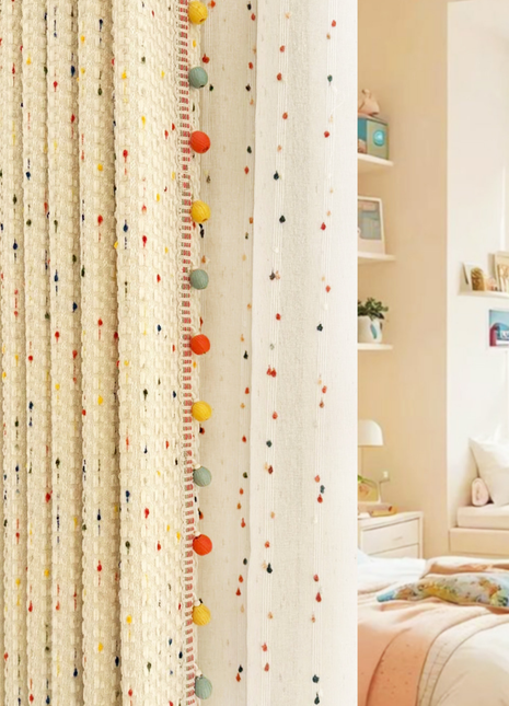 a bedroom with a bed, a shelf with framed pictures, and a curtain with colorful balls hanging from it.