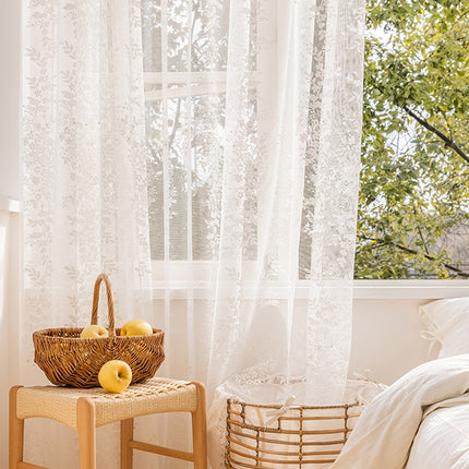 a basket of apples sitting on a table next to a window