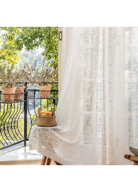 ein Fenster mit einem weißen Vorhang und einem Obstkorb