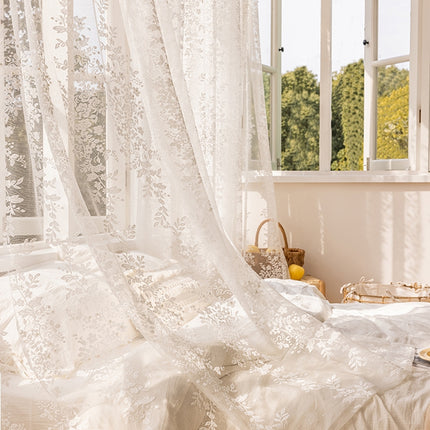 a bedroom with a white bed and white curtains