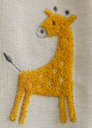 Nahaufnahme einer auf ein Stück Stoff gestickten Giraffe