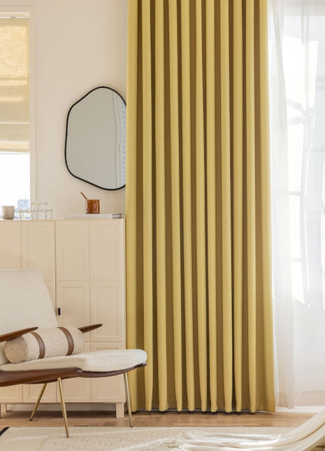 a living room with yellow curtains and a chair
