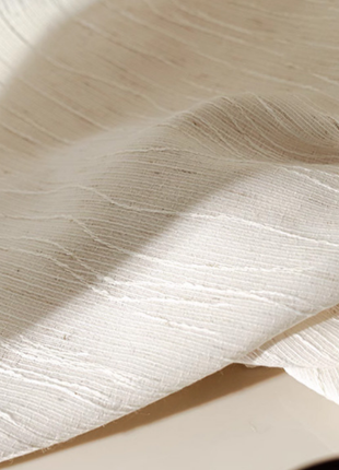 a close-up view of a white fabric with a textured, woven appearance.