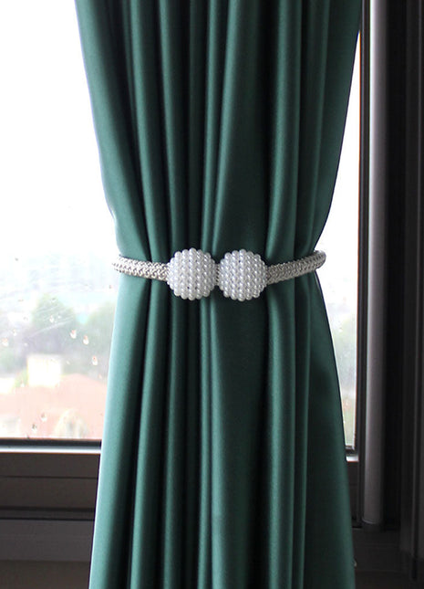 Grüner Vorhang mit zwei weißen Kugeln, der dem Interieur eine dekorative Note verleiht. Ideal als Dekorationsvorhang.